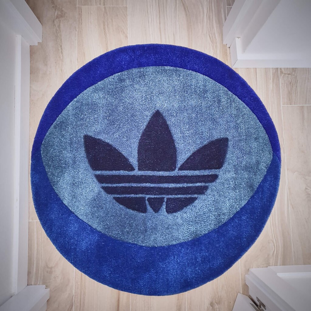 foto de una alfombra redonda con el logo de adidas originals en el centro adidas rug